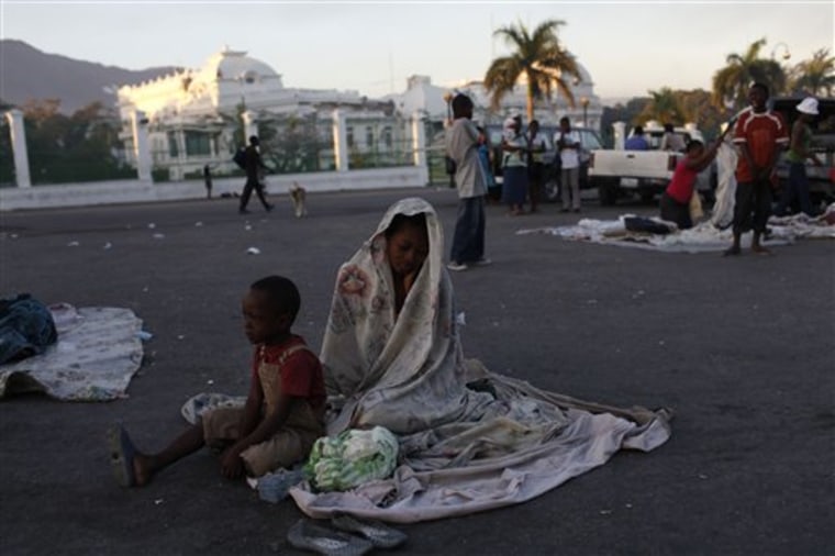 A woman and her son wake up after spending the night on the street in front of the collapsed National Palace in Port-au-Prince on Saturday.